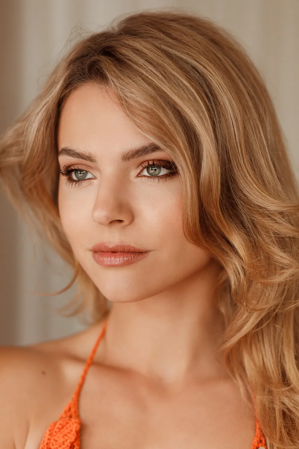 Portret van een vrouw met een zachte, glowy make-up en blond haar