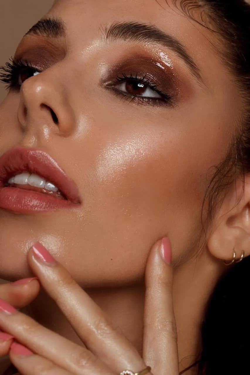 Close-up van een bruine smokey eye met glossy ooglid en stralende huid