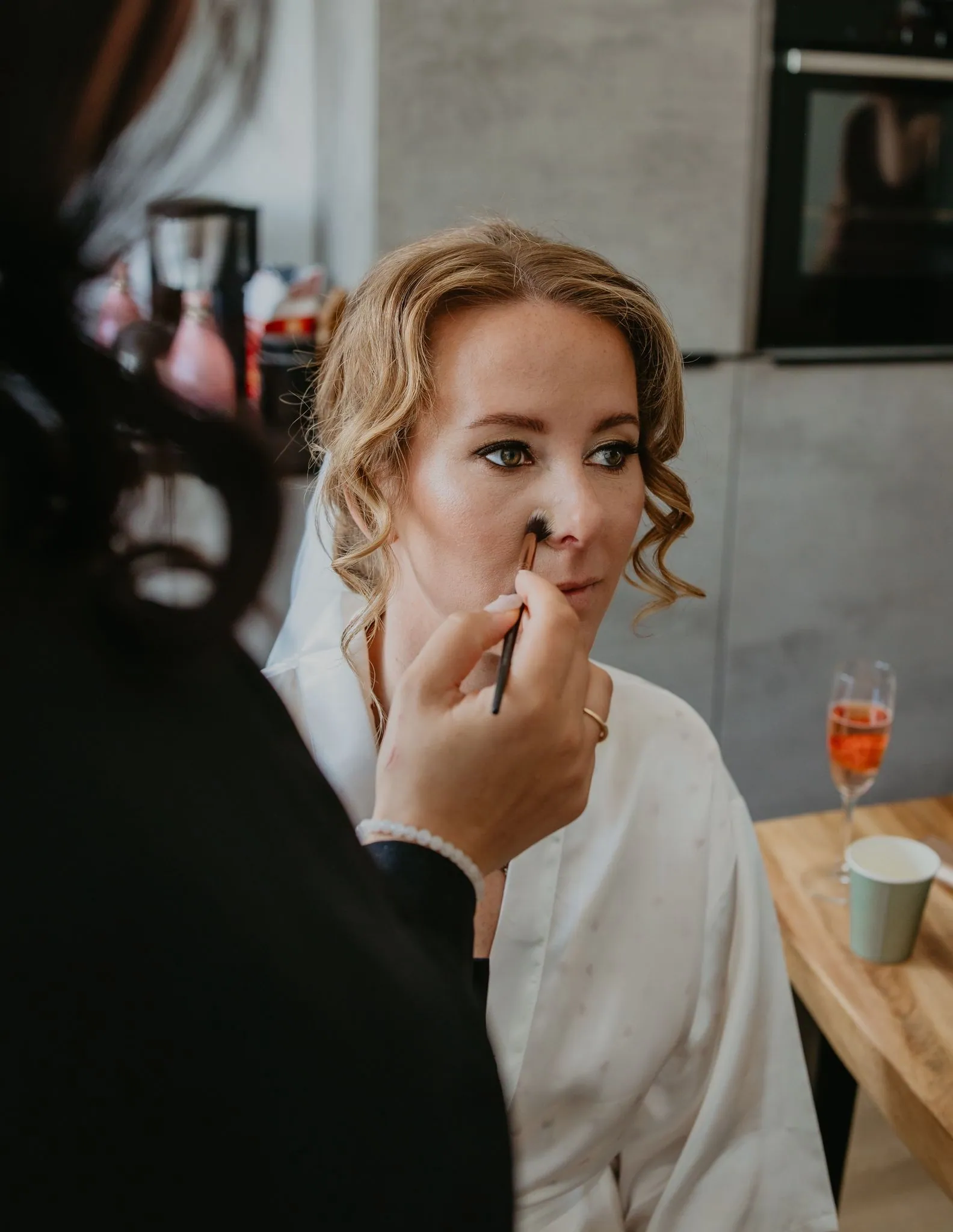 Bruid krijgt haar make-up op de trouwdag