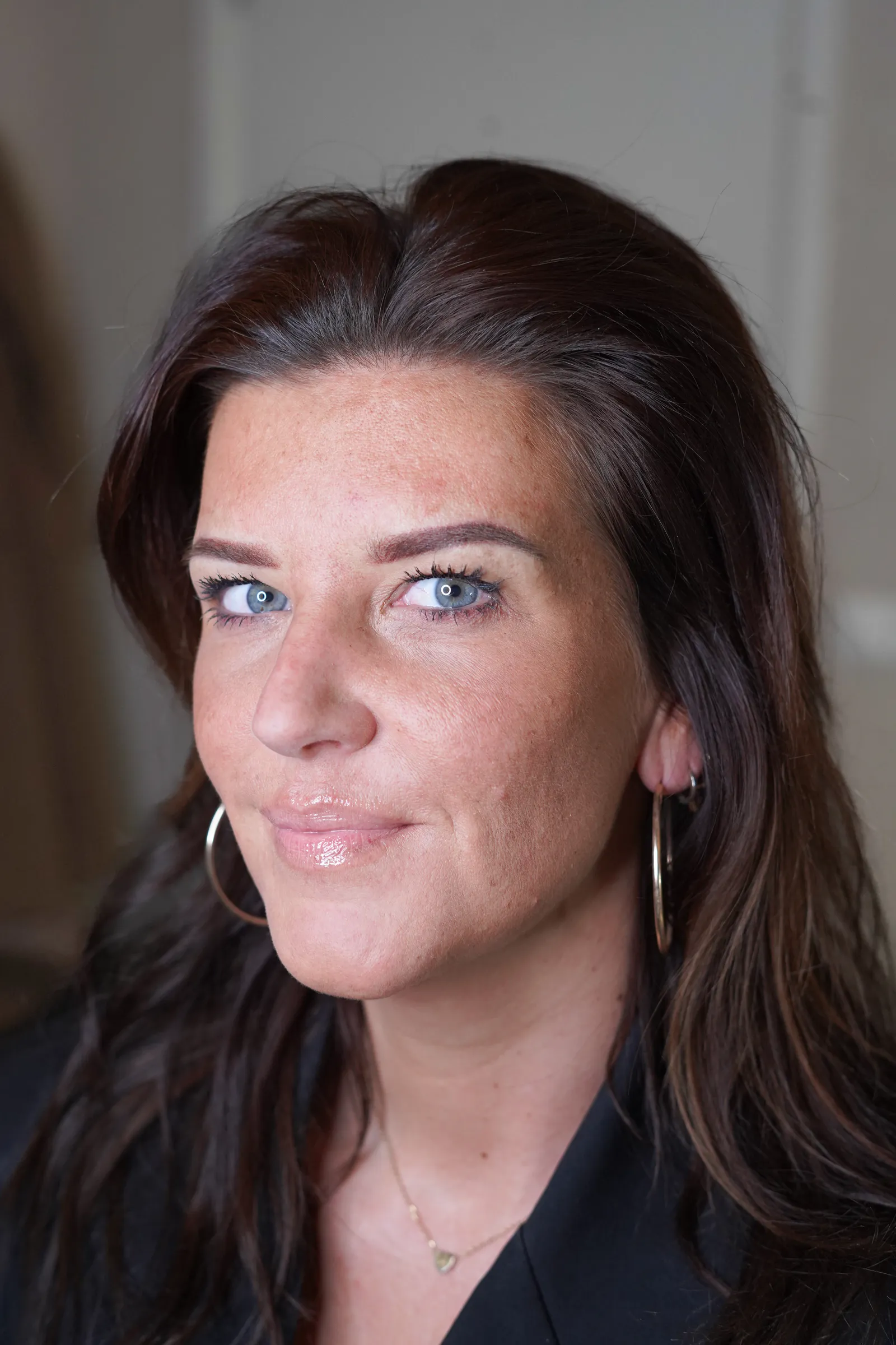 Klant met haar nieuwe powderbrows, blauwe ogen en oorringen